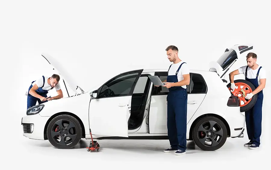 Mecànics revisant i reparant un cotxe blanc a taller professional